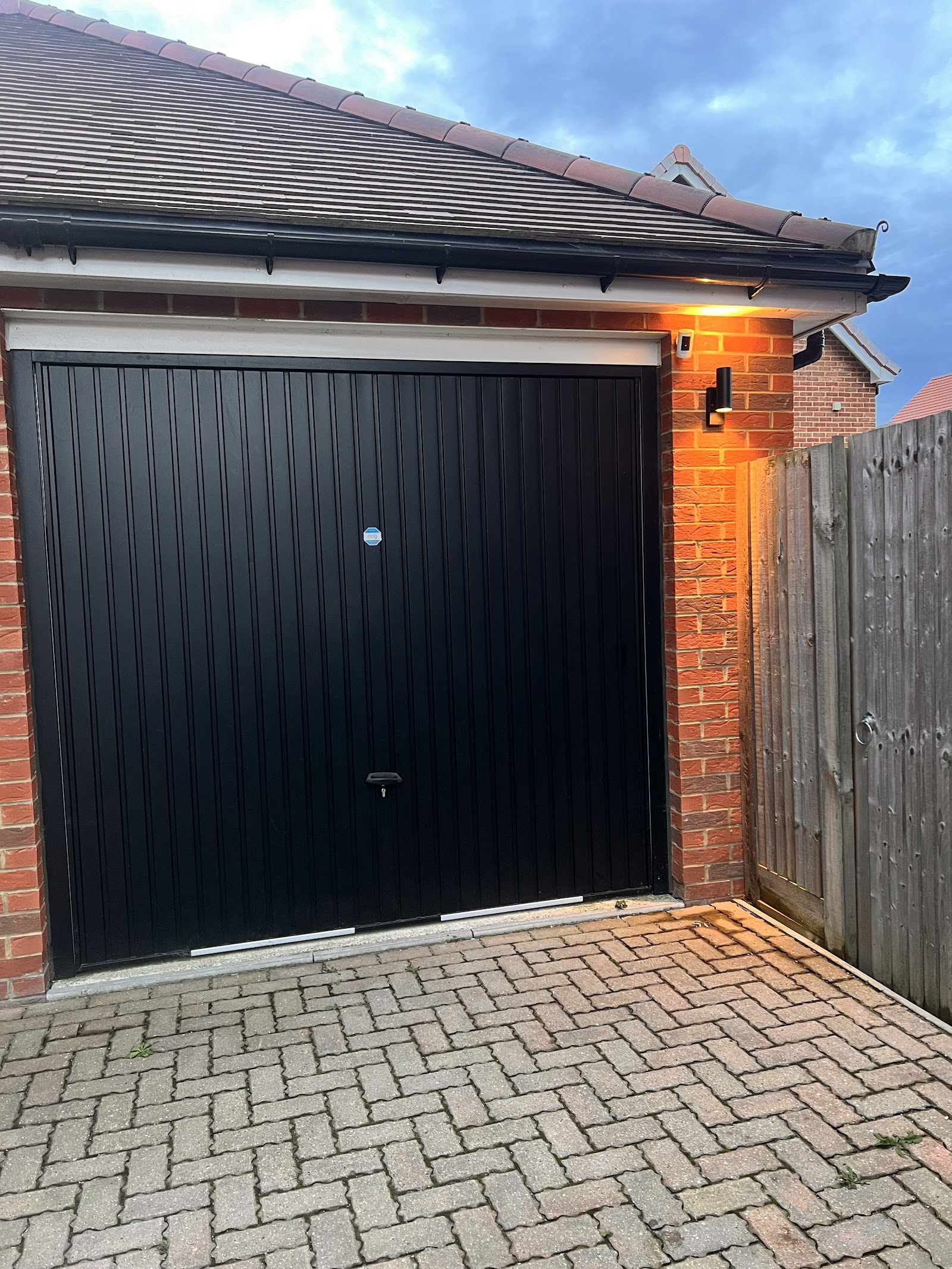 External wall light fitted to a garage corner, wired and weatherproofed.